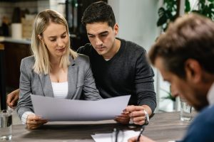 Casal jovem a analisar o crédito habitação com um agente imobiliário