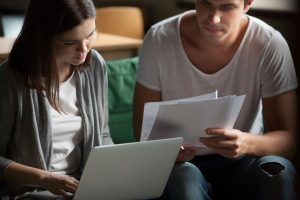 Casal a analisar papéis e orçamentos para pedir um crédito bancário ou financiamento de habitação