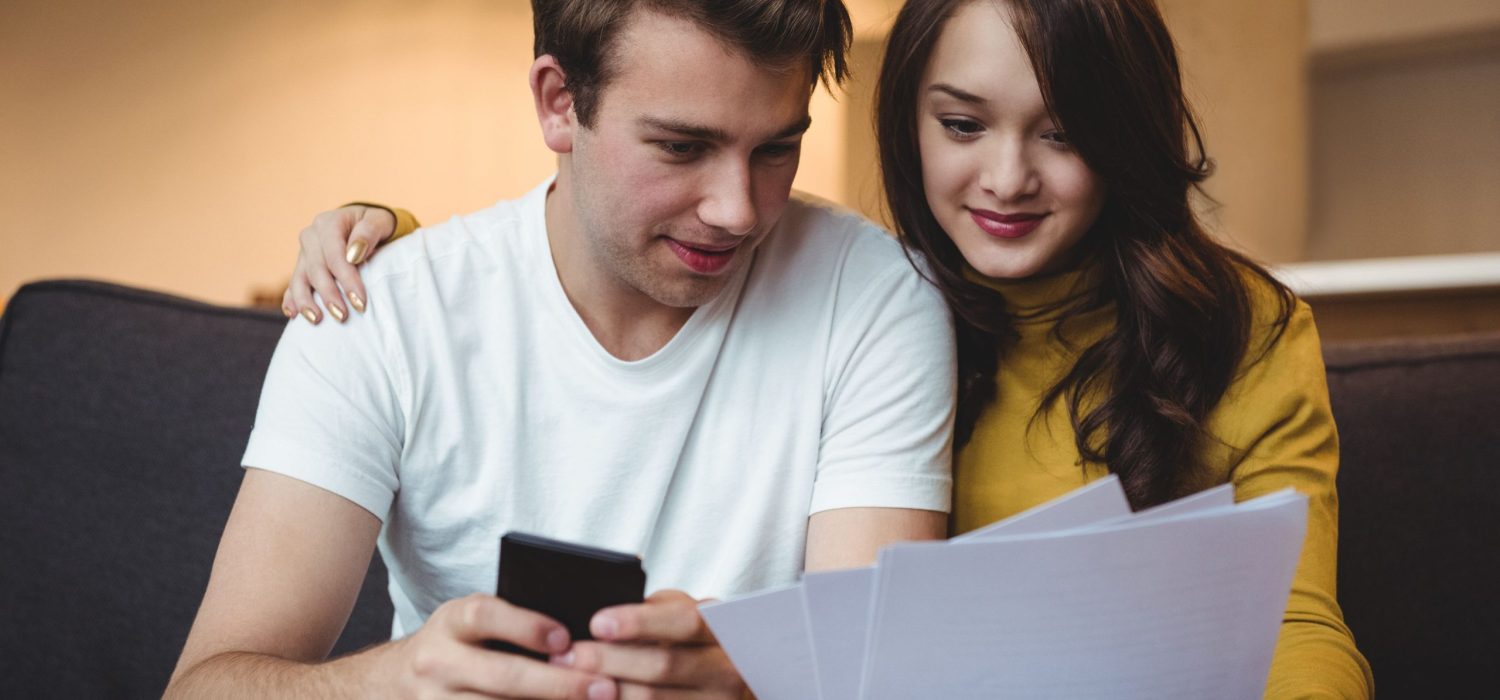 couple-discussing-with-financial-documents-calculator-living-room